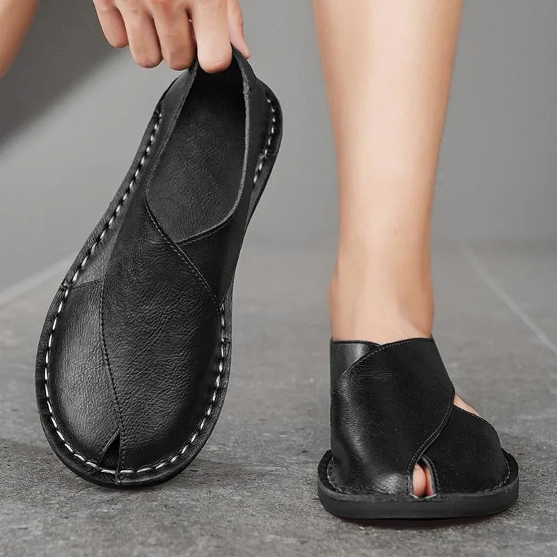Handcrafted black leather sandals with open toe design on concrete floor, Auretier footwear
