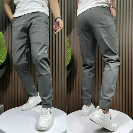 Model wearing gray stretch utility trousers from Auretier, front and back views, with white sneakers