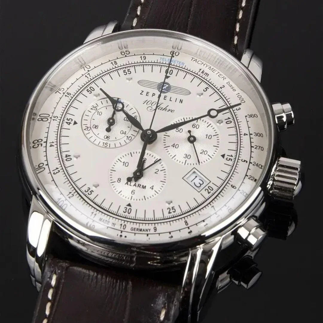Zeppelin men's chronograph watch with white dial, brown leather strap, and date window on black background