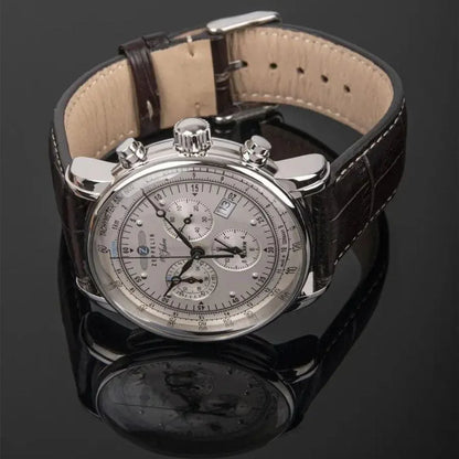 Luxury men's silver chronograph watch with brown leather strap on black reflective surface