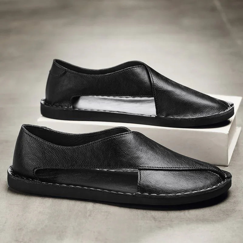 Auretier black leather slip-on sandals with cutout design on neutral background