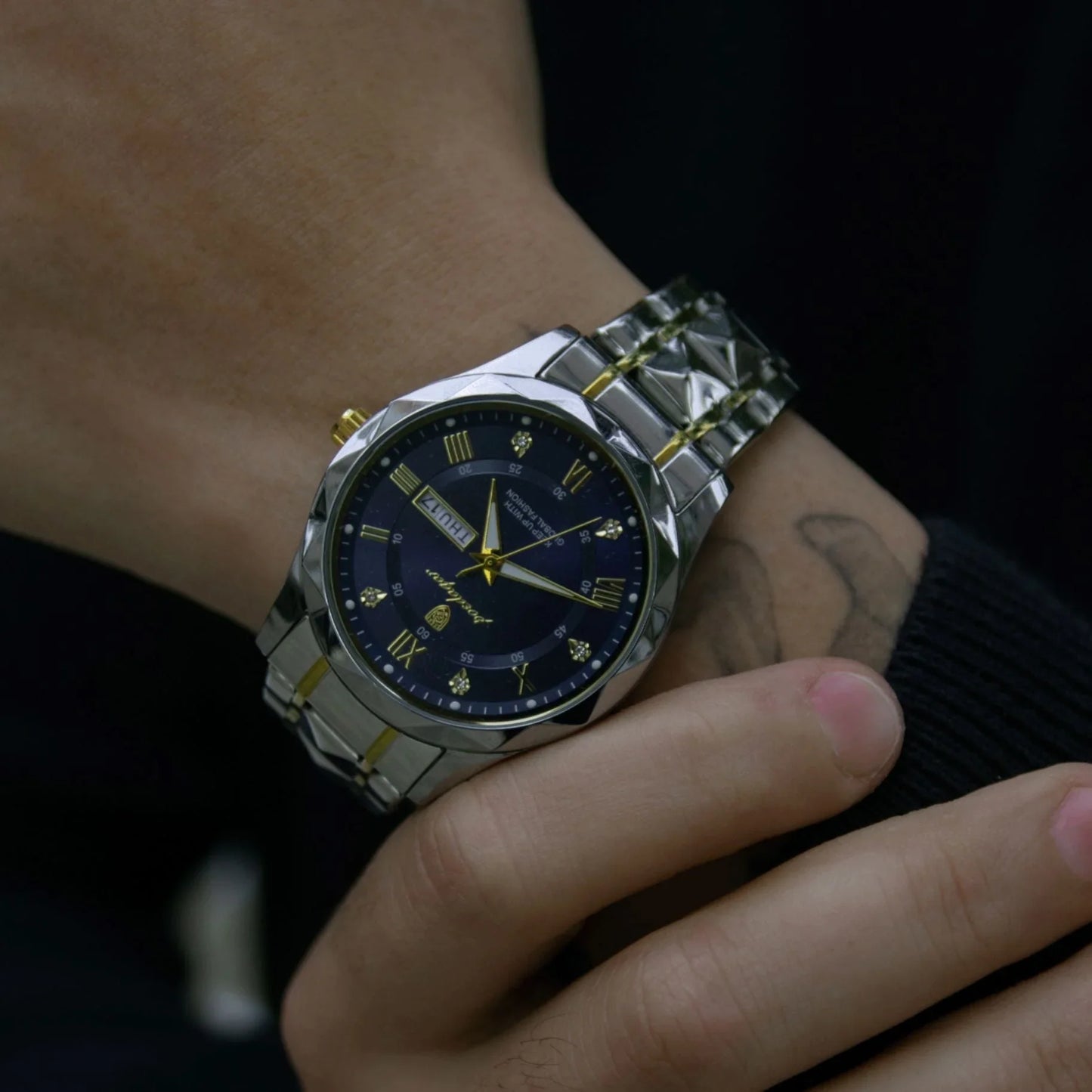 Luxury 40mm steel wristwatch with gold accents and blue dial worn on wrist, Auretier